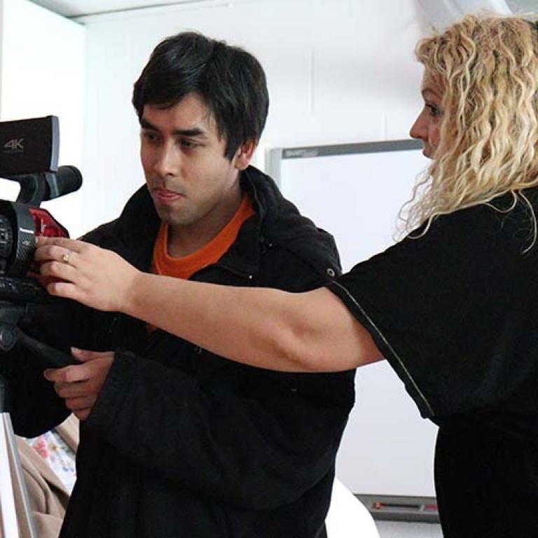 A Film Making workshop taking place inside Venture Community Centre. Sanya Mihaylovic is showing Jonathan Franco how to use the projects Panasonic camcorder. Photo taken by Darnell Da Costa 2019.