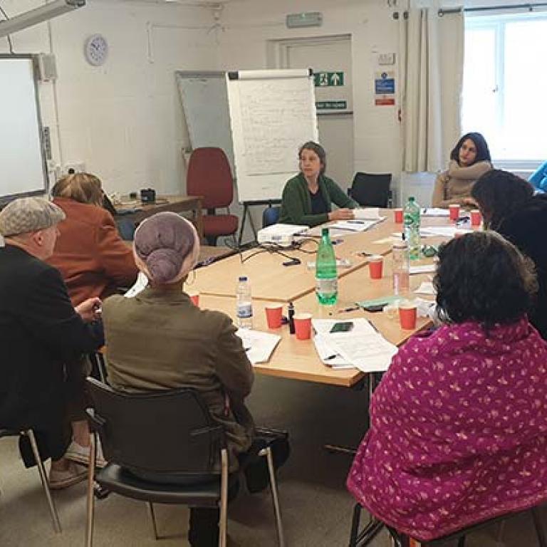 Oral History Training Workshop led by Rosa Schling taking place inside Venture Community Centre. The twelve participants are sitting around a table learning how to conduct an oral history interview. Photo taken by Talibah Stevenson 2019.