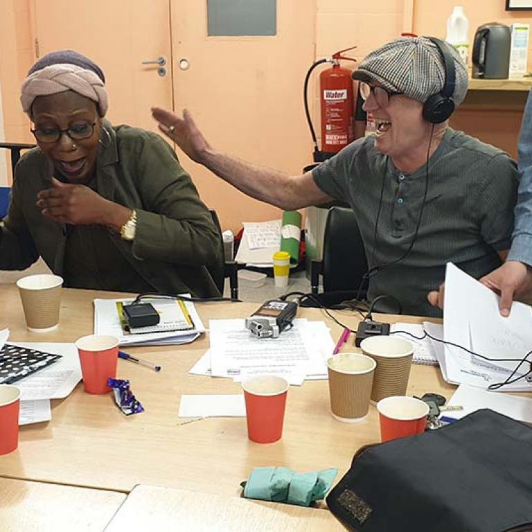 Oral History Training Workshop led by Rosa Schling taking place inside Venture Community Centre. Participants are laughing as they learn how to use the oral history recording equipment used when conducting an oral history. From left to right: Natasha Langridge, Grace Zikpi, Micky Pallant, Margaret Cairns-Irvin. Photo taken by Talibah Stevenson 2019.